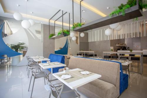 加的斯蒙泰波尔塔提亚拉酒店的餐厅设有白色的桌子和蓝色的椅子