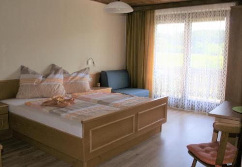 圣卡尼兹Die Sonnenblume的一间卧室配有一张大床、椅子和窗户