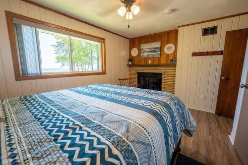 Beautiful home on Lake Michigan, near Escanaba的一间卧室设有一张大床和一个壁炉