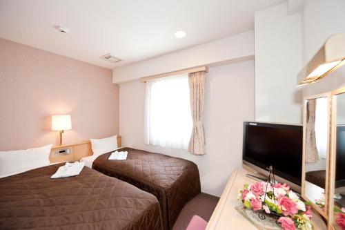 仙台尤丽斯特森戴经济酒店的酒店客房设有两张床和一台平面电视。