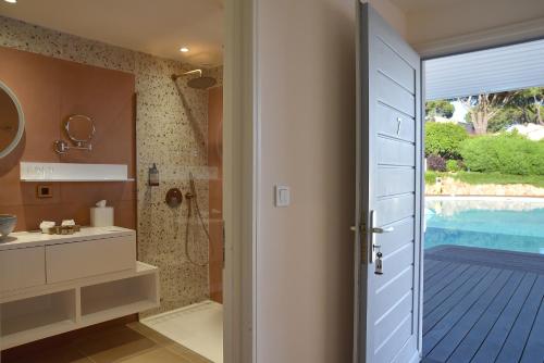 维琪奥港Hôtel Alivi Di Santa Giulia的带淋浴、水槽和门的浴室