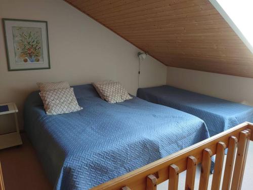塔库沃里Rivitalon huoneisto Tahkolla的一间位于阁楼的卧室,配有两张带蓝色床单的床