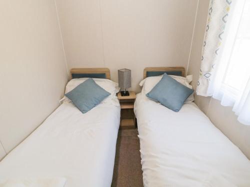莫珀斯Moon Stone的小客房内的两张床,配有蓝色枕头