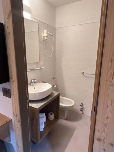库马约尔德格拉斯尔酒店的一间带水槽、卫生间和镜子的浴室