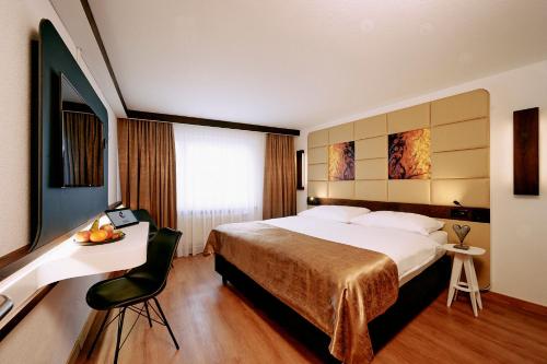 菲斯普伊里特酒店的酒店客房设有一张大床和一张书桌。