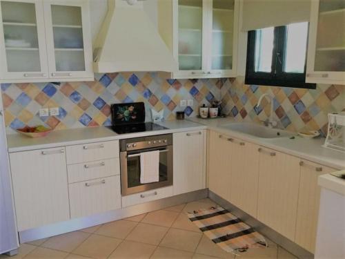 DhragoulásParos spacious apartment的厨房配有白色橱柜和炉灶。