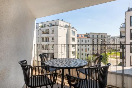 柏林numa I Boxer Rooms and Apartments的阳台配有桌椅和窗户。
