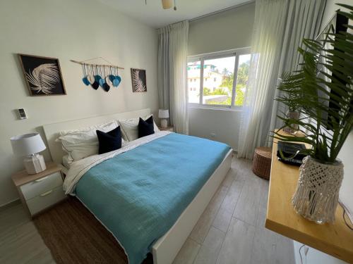 蓬塔卡纳Casa Mulata Paseo del Mar Pool & Playa的一间卧室配有一张带蓝色毯子的大床