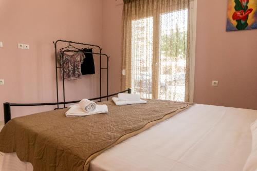 普雷韦扎Aktia Apartment, Preveza的一张带毛巾的床和窗户