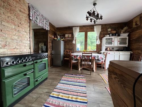 RykiOsmolicka Chatka的厨房配有绿色烤箱和桌子