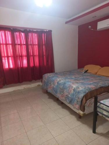 拉班达La Casa de Los Mellis..的一间设有红色窗帘的卧室和一张位于客房内的床
