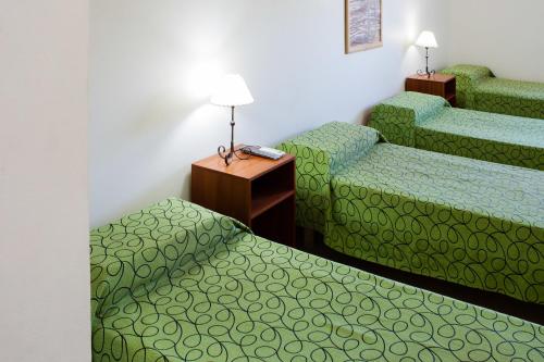 圣路易斯El Amparo Hotel的酒店客房设有两张床和一张桌子。