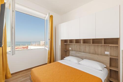 托瓦尼亚Residence Torvaianica的一间卧室设有一张床和一个大窗户