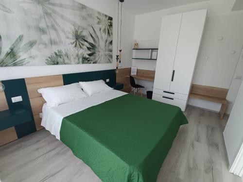 雷卡纳蒂港Corso Matteotti 162 - Affittacamere的一间卧室配有一张带绿床罩的床