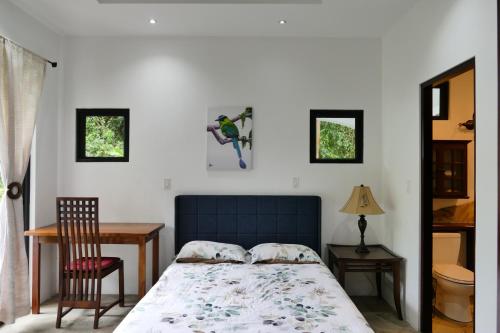 Bajo BoqueteCasitas Vista Verde的卧室配有1张床、1张桌子和1把椅子
