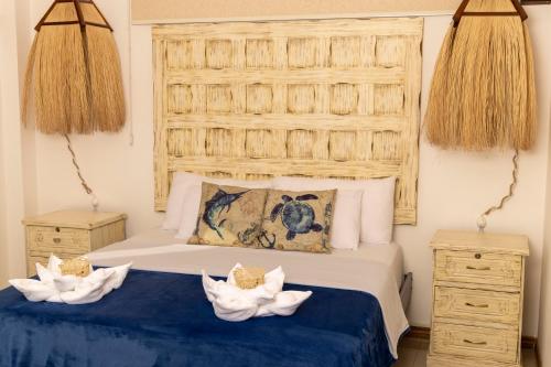 巴克里索莫雷诺港Galapagos Planet Hotel的一间卧室,配有一张带两顶帽子的床