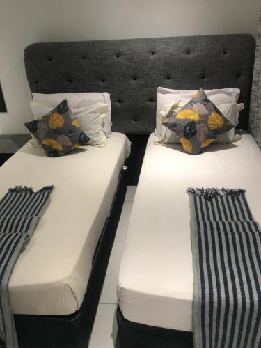 马翁Jayla Homestay的配有2张床的带白色床单和枕头的客房