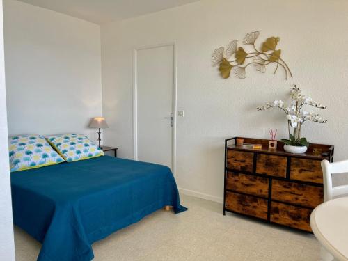 圣拉斐尔Grand Studio 4 pers - VUE MER的一间卧室配有蓝色的床和梳妆台