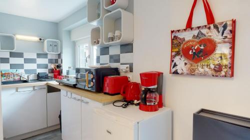科尔马Studio avec parking Rue de la Semm的柜台上配有红色用具的厨房