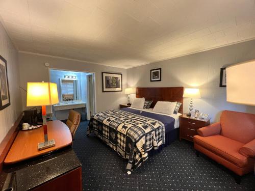 麦基诺城美国精品旅馆 - 湖景的配有一张床和一把椅子的酒店客房
