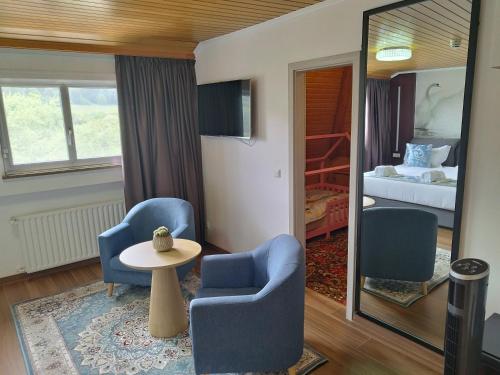 埃讷安hotel whiteswan的一间设有两把椅子、一张桌子和一张床的房间