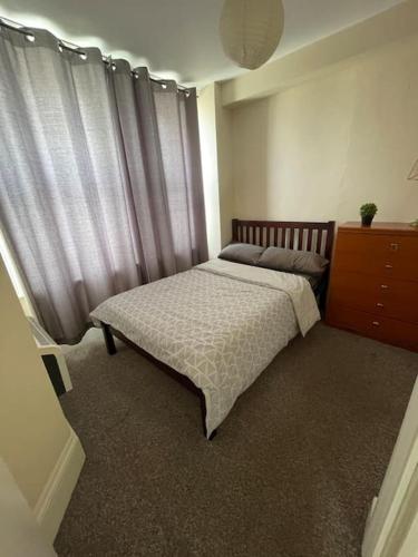 布莱顿霍夫Flat in Brighton city centre的一间卧室配有带窗帘的床和梳妆台