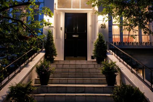 伦敦道森广场朱丽叶住宿加早餐旅馆的楼梯房子上的黑色门