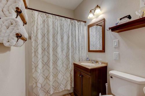 温泉城Mountain Bungalow-Walk to Downtown/Biker's Dream!的浴室设有白色的淋浴帘和水槽