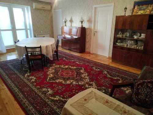 甘贾Friends Guest House的客厅配有桌子和地毯。