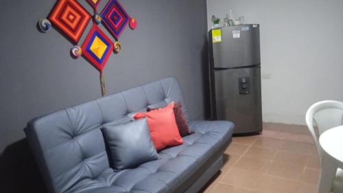 里奥阿查apto #5 cómodo y acogedor en lugar estratégico的厨房配有蓝色沙发、枕头和冰箱