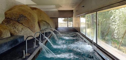 RetortilloBALNEARIO DE RETORTILLO的一个大岩石的房间内的热水浴缸