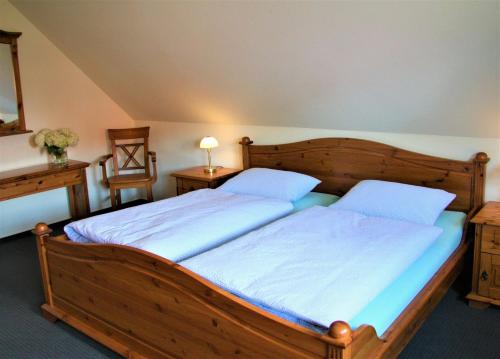 吕肖Plater Hermann的一间卧室配有一张带两个枕头的大木床