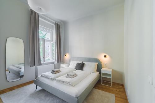 格拉茨Premium apartment - walking distance to city center的白色卧室配有床和镜子