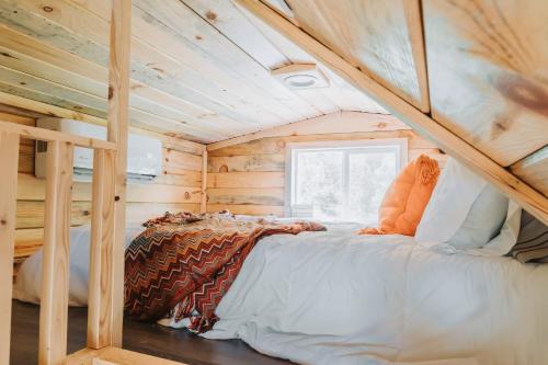 彭延Hollow Hills Tiny Home的小屋内的一张床位,设有木制天花板