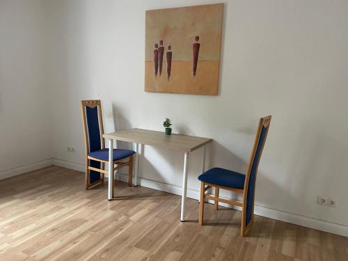 威廉港Schönes einfaches Zimmer im belebten Zentrum的一张桌子和两把椅子以及墙上的一幅画