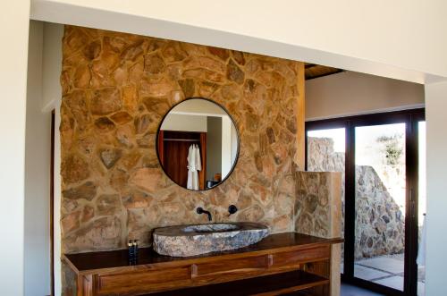 克鲁格斯多普Sibani Lodge的石质浴室设有水槽和镜子