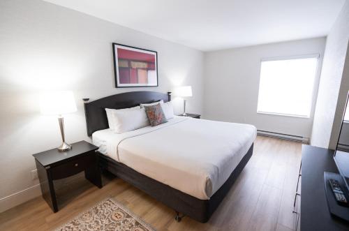 渥太华商旅套房酒店的一间卧室设有一张大床和一个窗户。