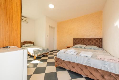 乌尔齐尼Apartmani Medovic的一间卧室设有两张床,铺有一个 ⁇ 板地板