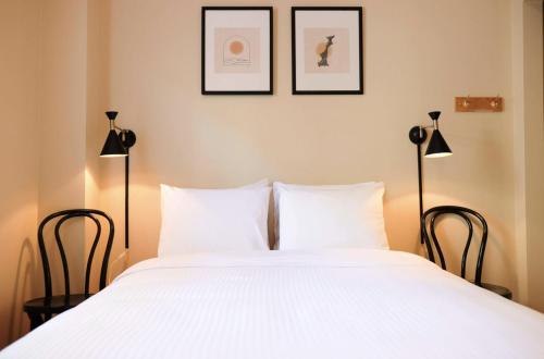 尼尔逊Dancing Bear Inn Hostel的一间卧室配有一张带两盏灯的大型白色床。
