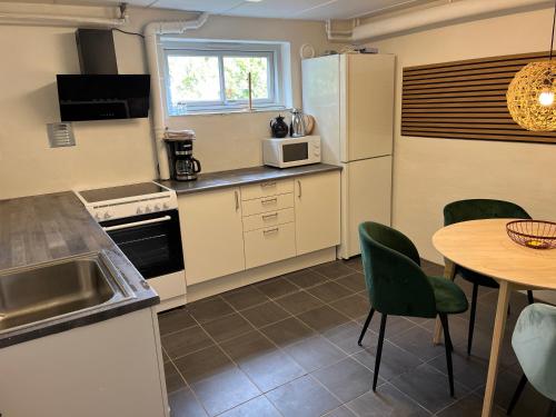 Tølløse120 kvm lejlighed med have i kælderniveau的厨房配有桌子和冰箱