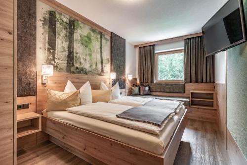 迈尔霍芬伊方歌尔乡村公寓的一间卧室配有一张大床和一台平面电视