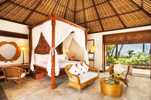 塞米亚克The Oberoi Beach Resort, Bali的一间卧室配有天蓬床、沙发和椅子