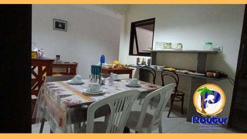 马塞约波尔图尔旅馆的一间带桌椅的用餐室和一间厨房