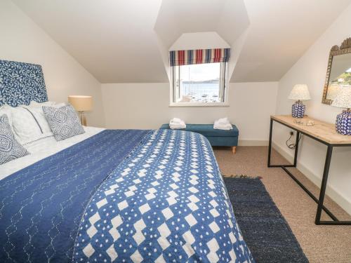 法尔茅斯16 Arwenack Street的卧室配有蓝色和白色的床和窗户。