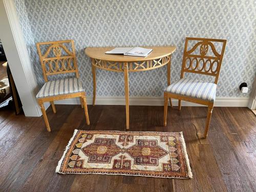 瓦斯泰纳Lovisas Stuga的一张桌子、两把椅子和一张桌子,地毯