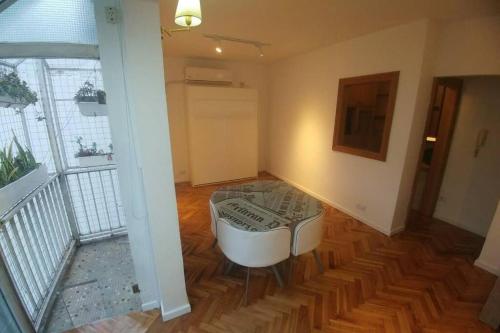 布宜诺斯艾利斯Monoambiente Palermo temporario的客厅铺有木地板,配有白色椅子