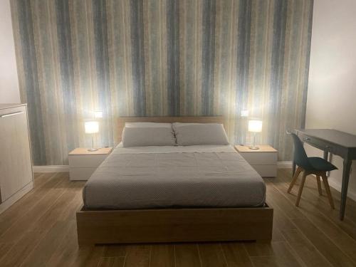 塔兰托Il Pavone的一间卧室配有一张床和一张带两盏灯的书桌。