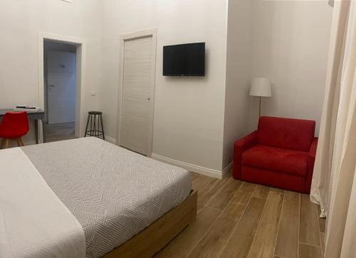 塔兰托Il Pavone的一间卧室配有一张床和一张红色椅子