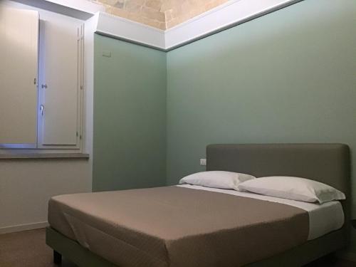 瓦斯托VILLA ACTEA的绿色墙壁间的一张床位