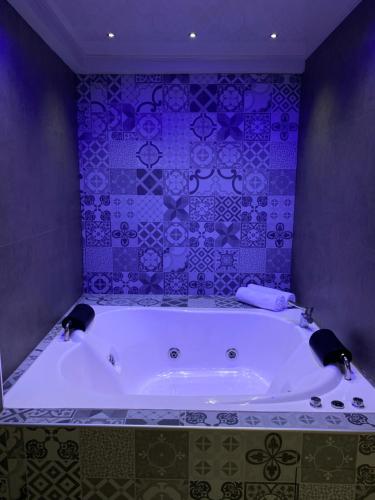 科恰班巴Izza Hotel的浴室设有大浴缸,铺有紫色瓷砖